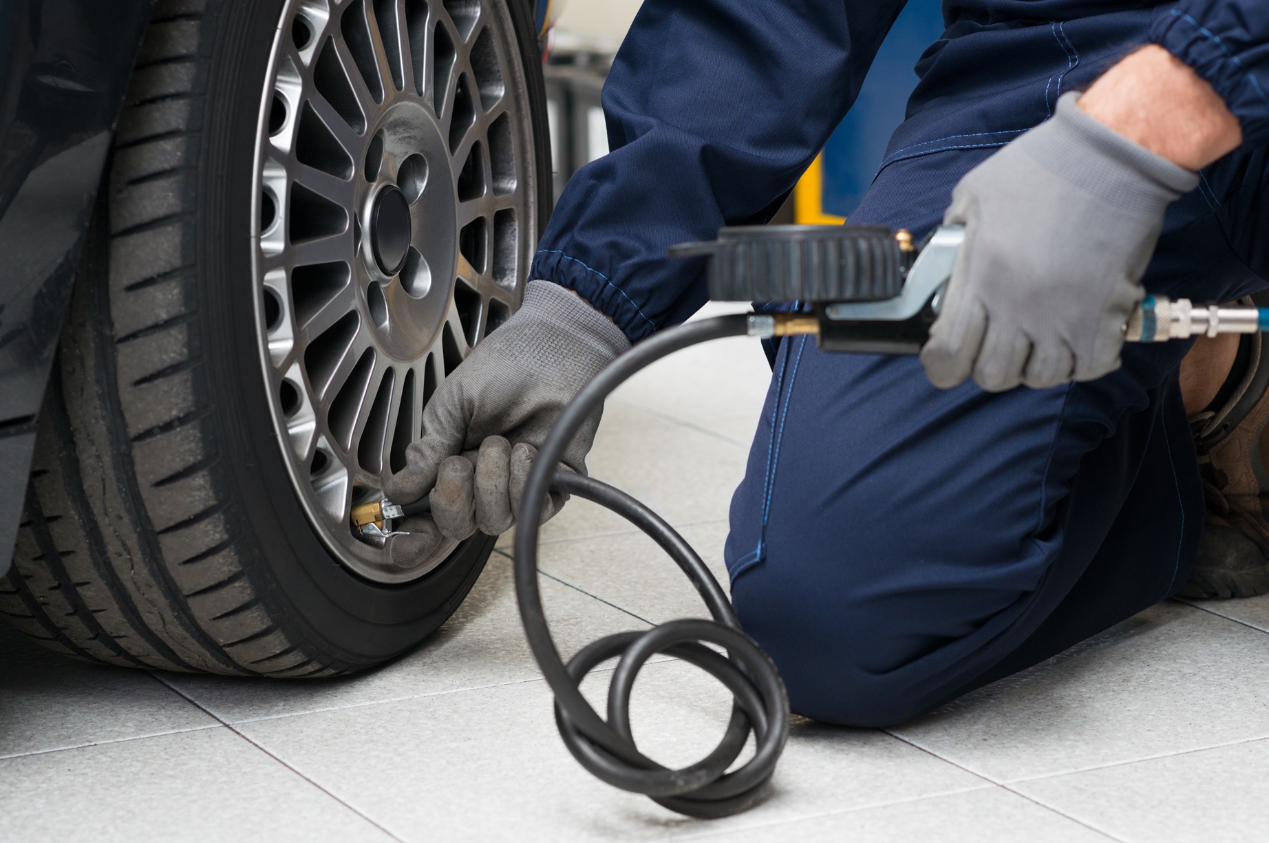 Mechanic_checking_tyre_pressure_with_gauge.jpg